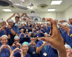 A photo of somebody taking a photo on a mobile phone of a group of NHS healthcare staff. 