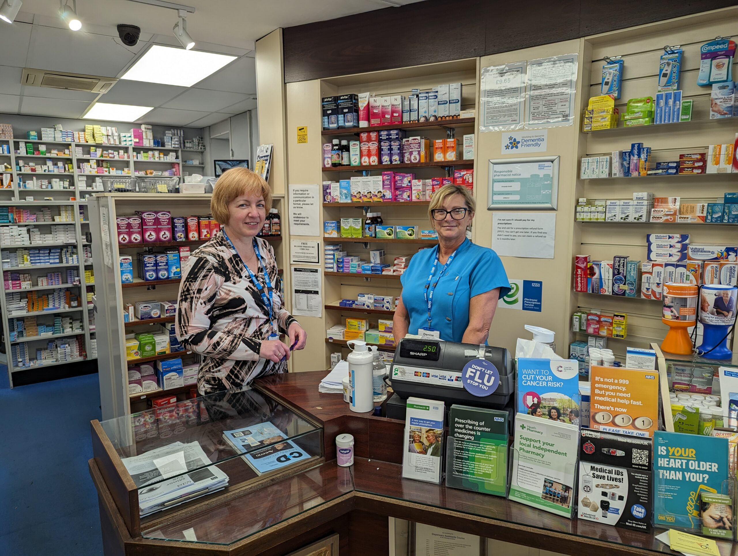 Community Pharmacist Amanda Smith and dispenser Denise Briscoe stand behind the counter within their pharmacy