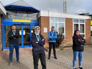 FOUR PEOPLE STOOD OUTSIDE HOSPITAL