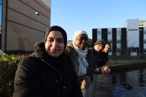 FOUR PEOPLE LEANING OVER BAR OUTSIDE HOSPITAL