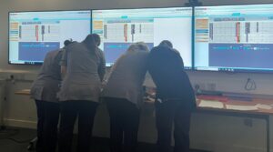 FOUR HEALTH CARE PEOPLE STOOD IN FRONT OF A SCREEN