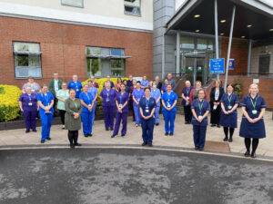 Group of people posing for photo outside hospital