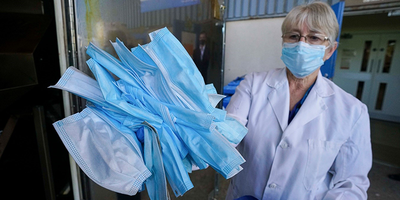 a woman holding surgical masks