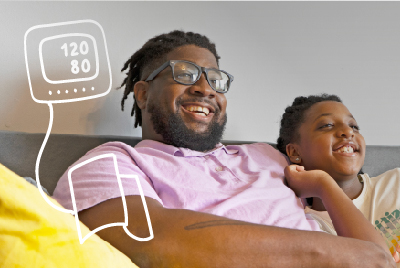 a man and a child sitting on the sofa. the man is having his blood pressure checked.