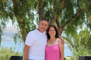 Image shows a man who has survived cancer after being diagnosed with testicular cancer. Stood beside him is a woman who is his wife. 