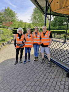 Three women and a man in hi-vis jackets about to go for a walk