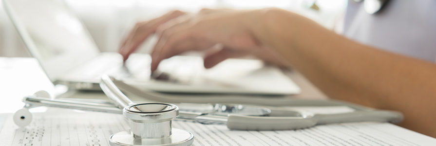 Close-up of a doctor typing on keybord in the office