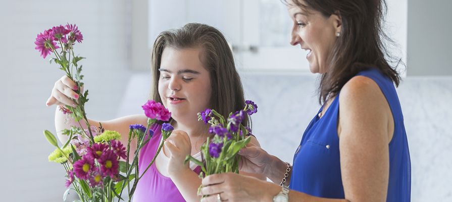 A teenage girl with learning disabilities arranges some flowers