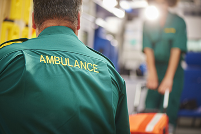 An ambulance crew pulling a stretcher