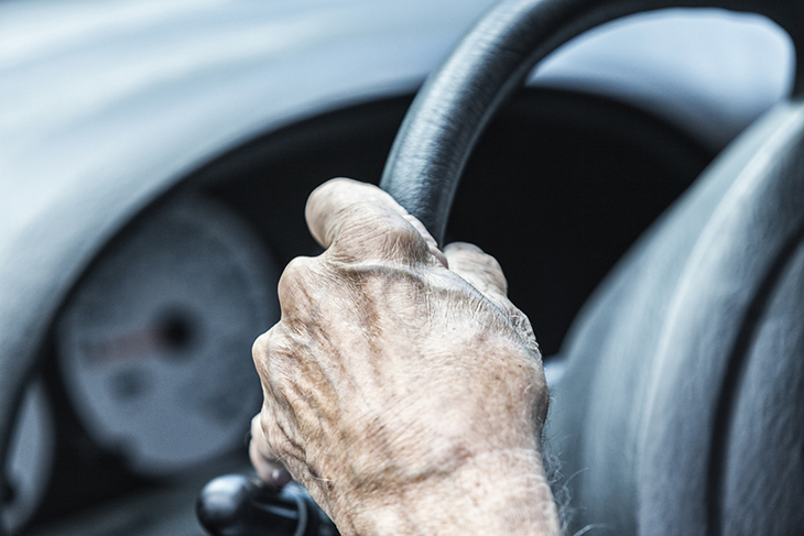 A close up of a hand on a steering wheel