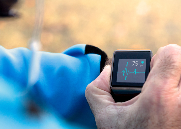 A man checks his heart rate on a wrist monitor