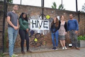 A group of young people standing by The Hive sign