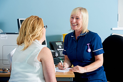 Female nurse talking to a female patient