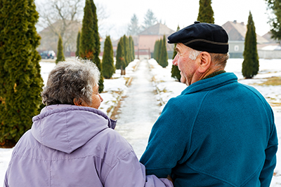 Elderly couple walking in the snow.