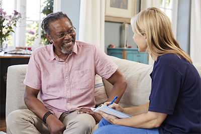 Female support worker visits senior man at home