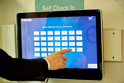 A person pointing to a touchscreen display unit