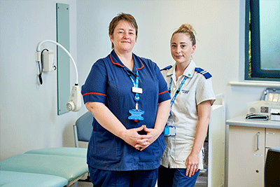 Two healthcare professionals standing in a hospital room