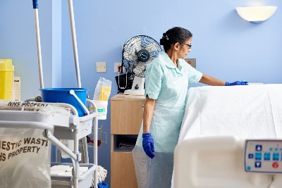 Image of a member of staff cleaning a hospital room.