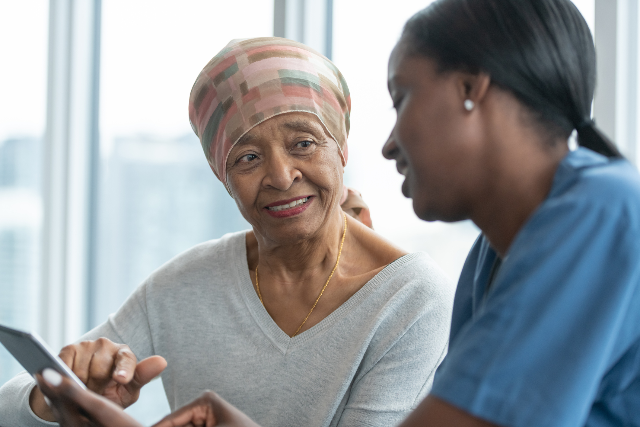 Woman with cancer reviews test results with female doctor