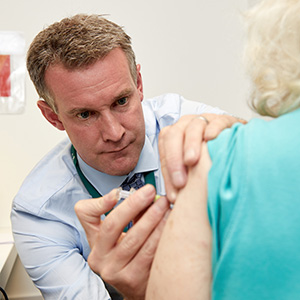 Photograph of a healthcare professional vaccinating a patient.
