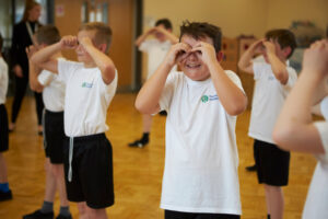 Children dressed in school PE kit playing a game