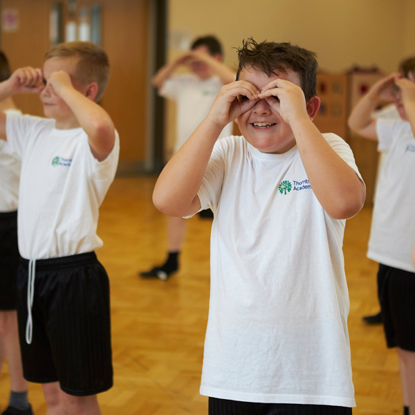 Children in their school PE kit playing games in a sports hall