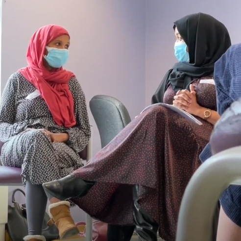 Two women talking at a meeting