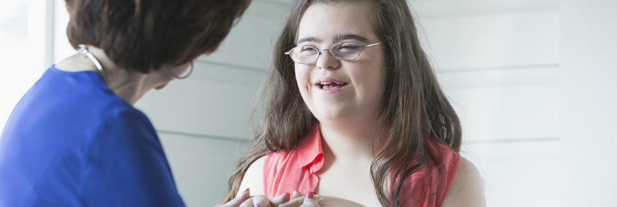 A teenage girl with down syndrome smiling