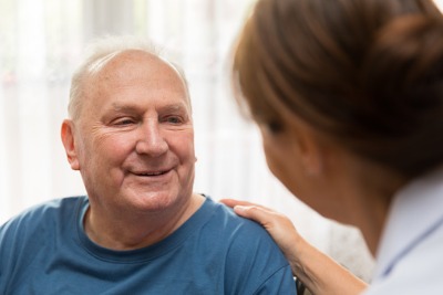 Female nurse talking to male patient