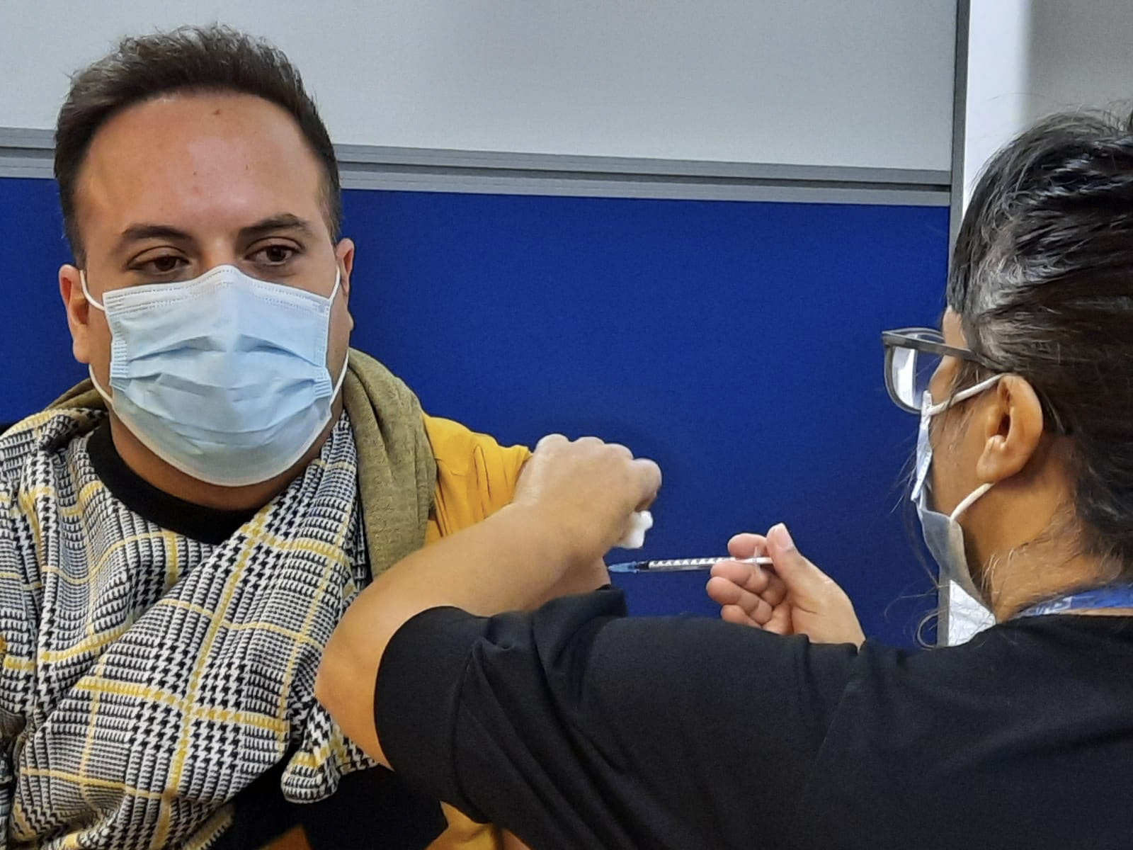 Man wearing mask being given vaccine