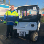 Photo of Martin Bryan standing beside a shuttle buggy