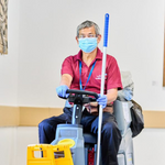 A photo of Ricky Yung driving a ride-on cleaning machine through a hospital