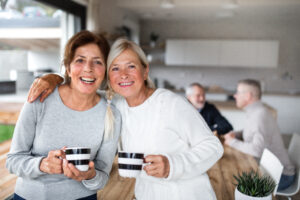 women with coffee at home, looking at camera.