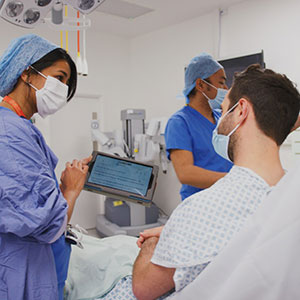 A patient and two healthcare professionals in an operating theatre