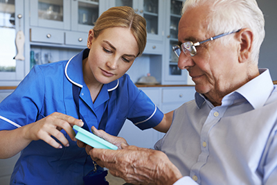 A nurse helps a patient with his medication