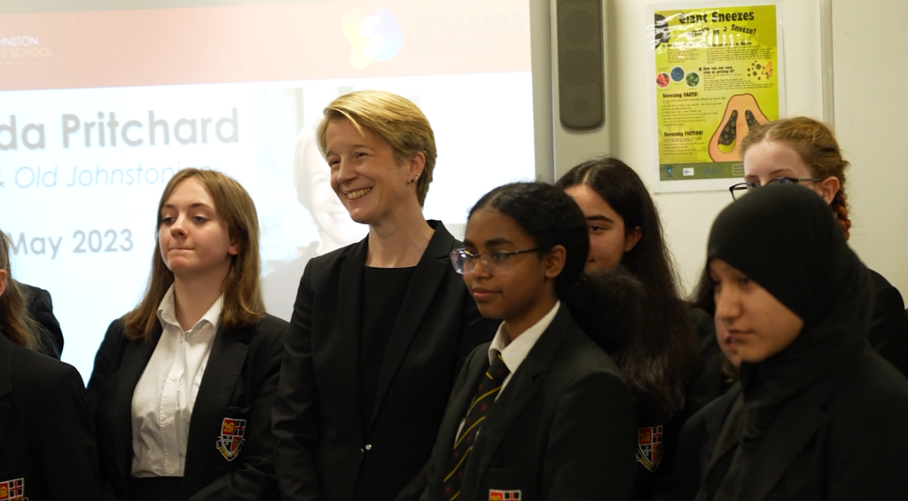 Amanda Pritchard standing with a group of school pupils