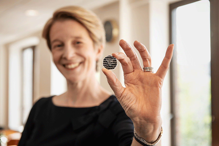 Amanda Pritchard holding the new 50 pence coin celebrating the 75th birthday of the NHS.