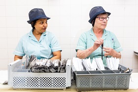 two woman sorting out some utensils 