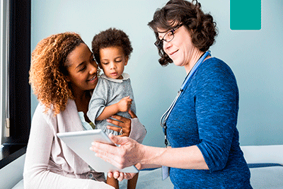 A healthcare professional talking to a patient and her child.