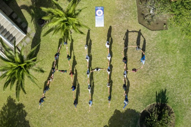 A top-down view as a group of people link arms and arrange themselves to spell out 'AHP'