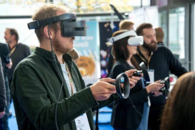 A young trainee wearing a VR headset to engage in training at a conference event, busy with other people in the background.